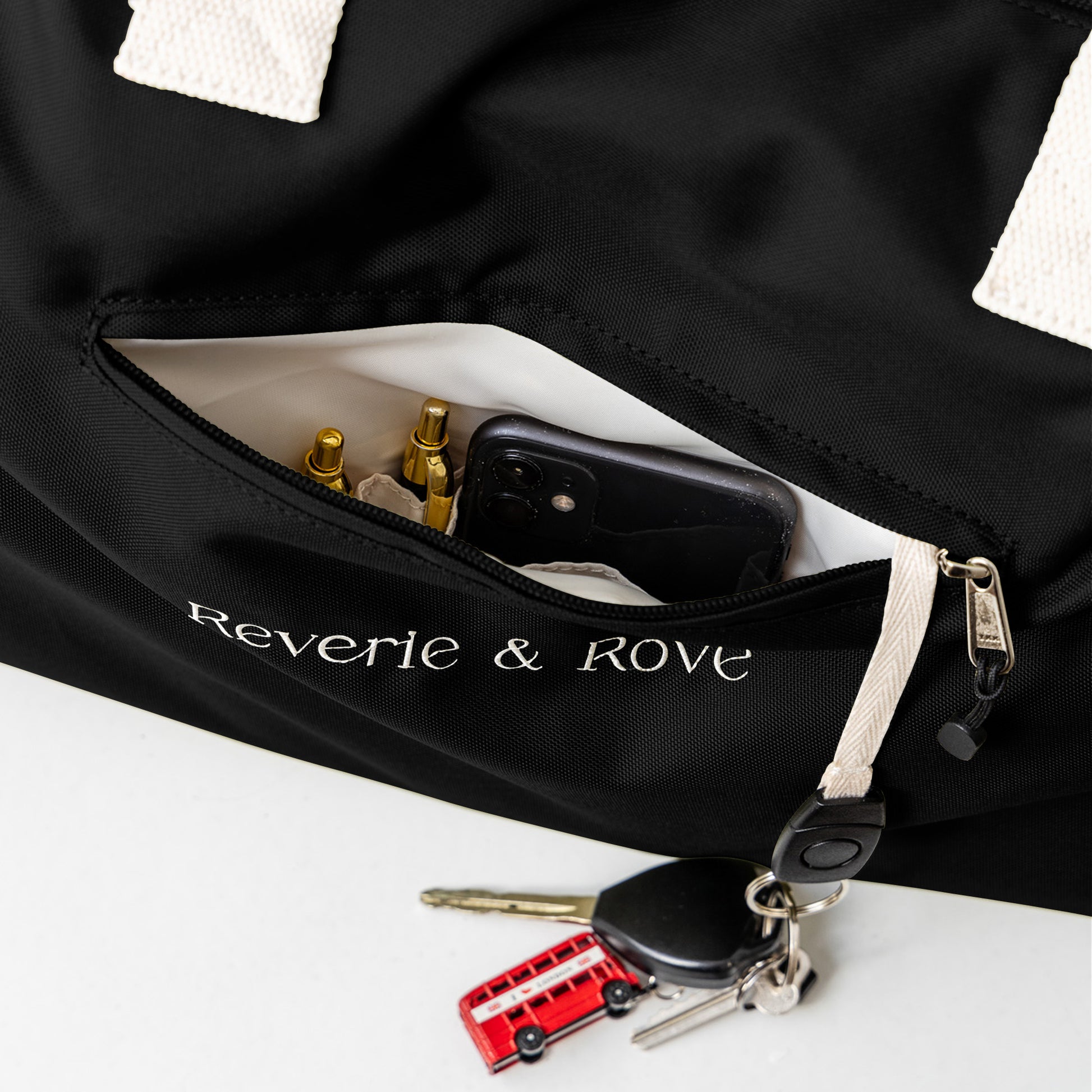 Black duffle bag quick access pocket with key tag