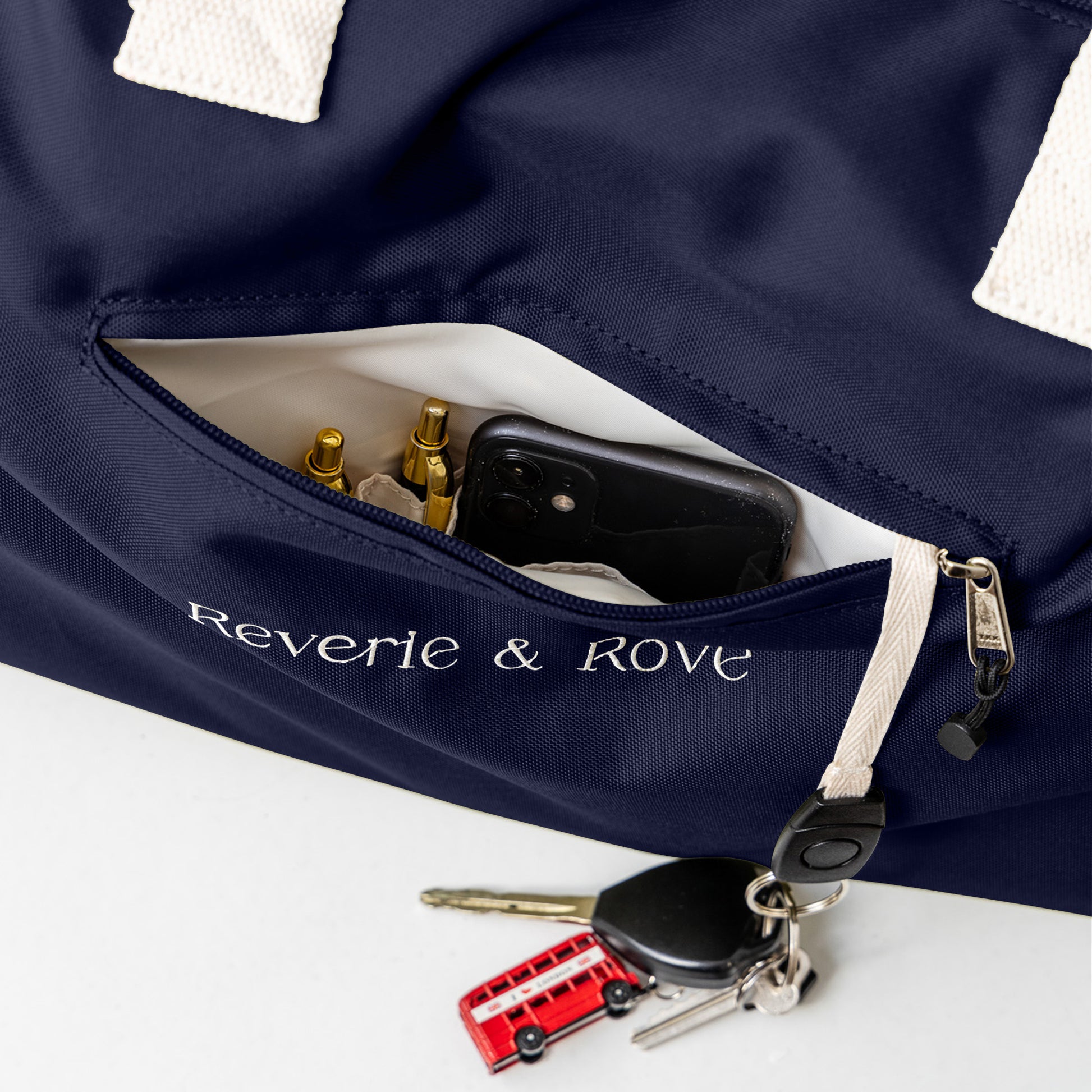 Navy duffle bag front showing quick access pocket and key tag