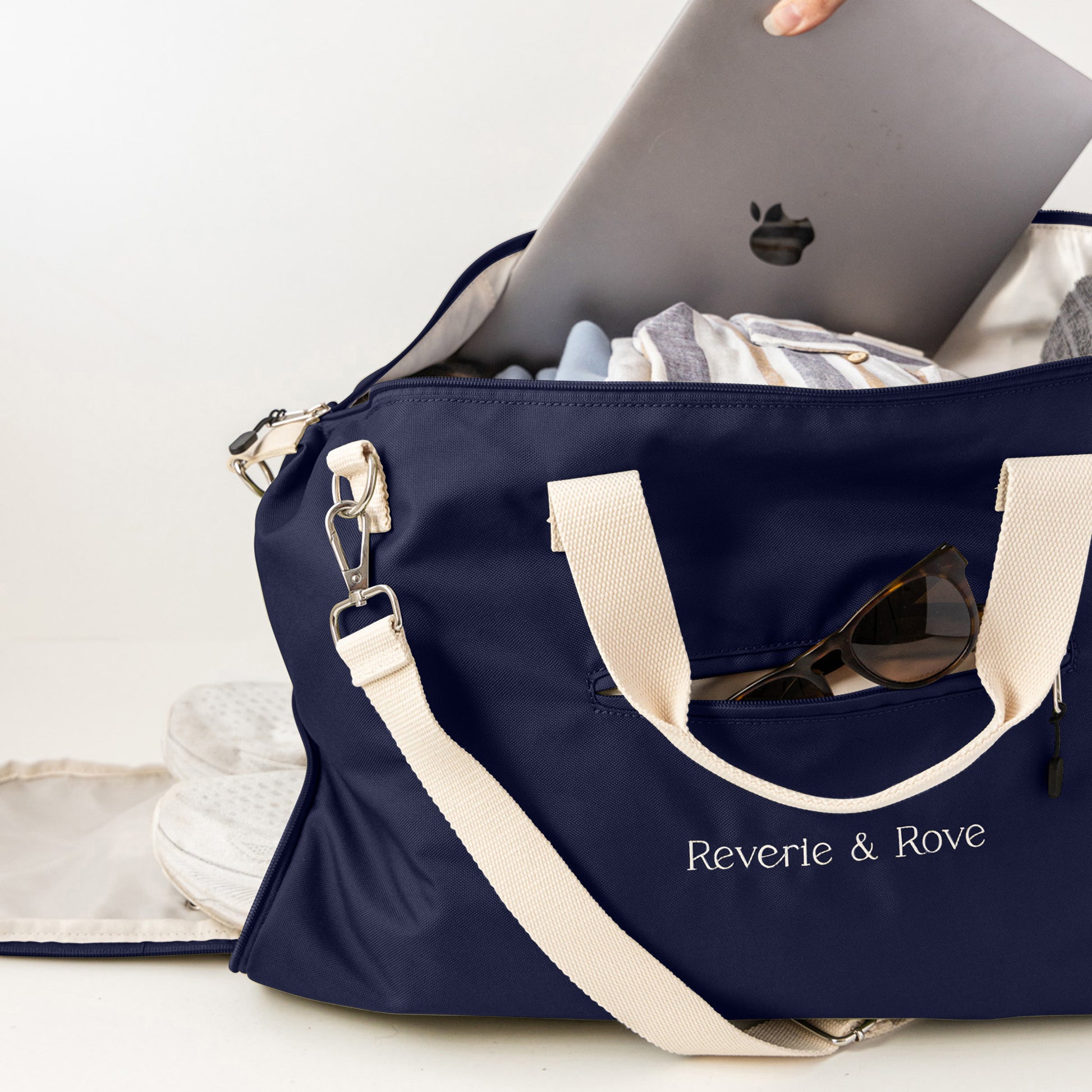 Navy duffle bag packed for work and travel showing multiple features
