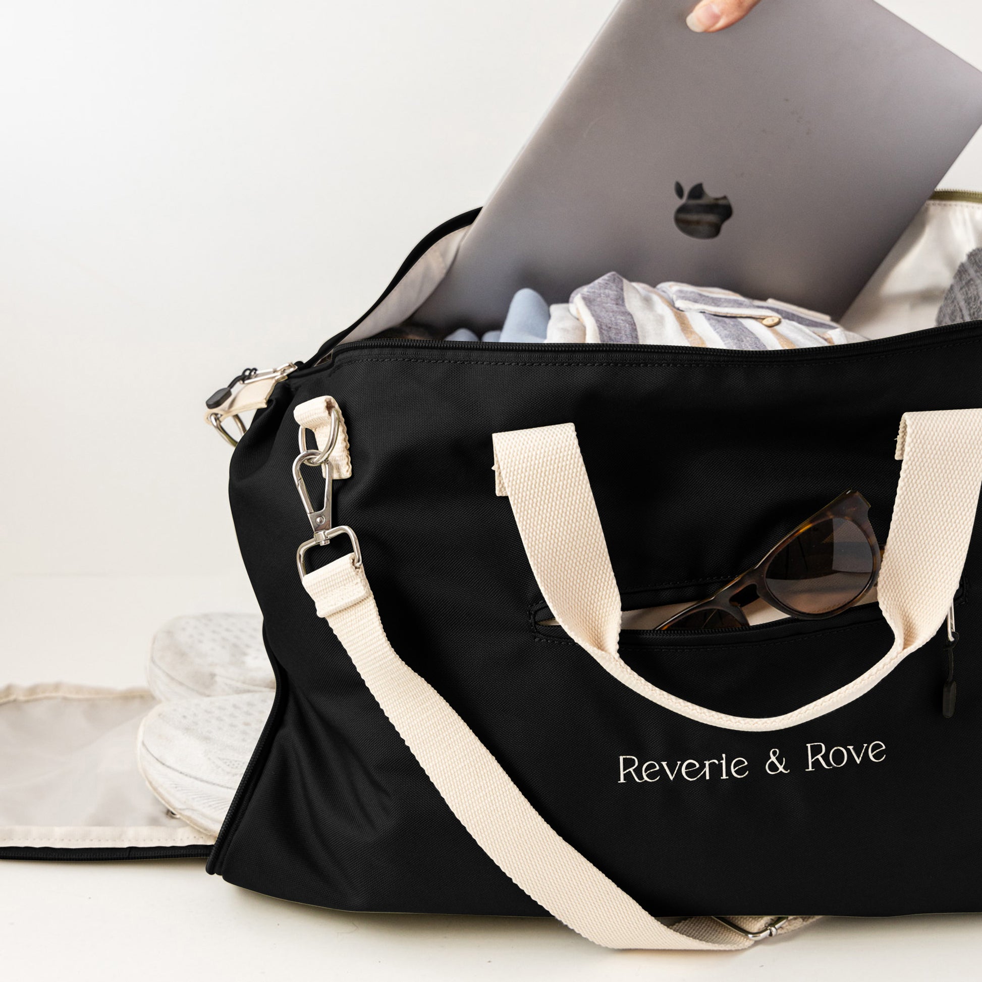 Black duffle bag packed for working holiday showing multiple features