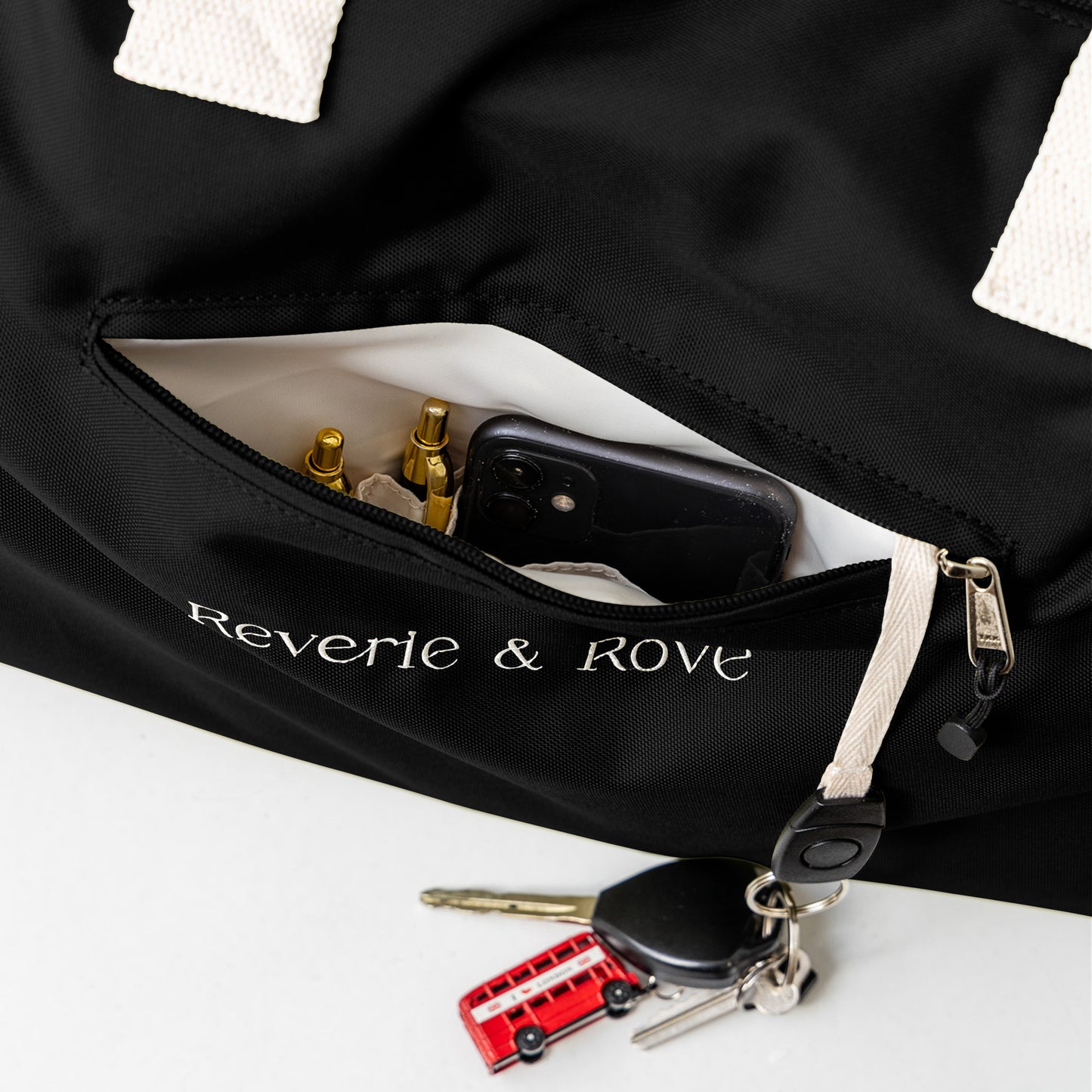 Black duffle bag quick access pocket with key tag