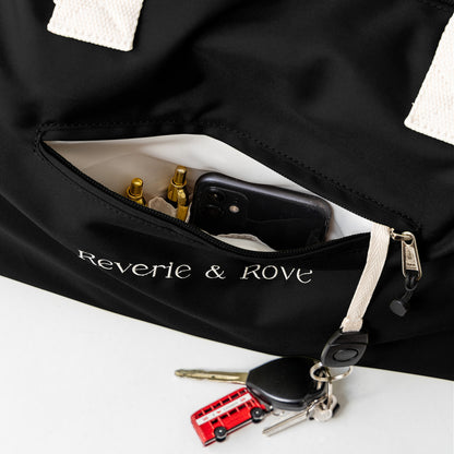 Black duffle bag quick access pocket with key tag