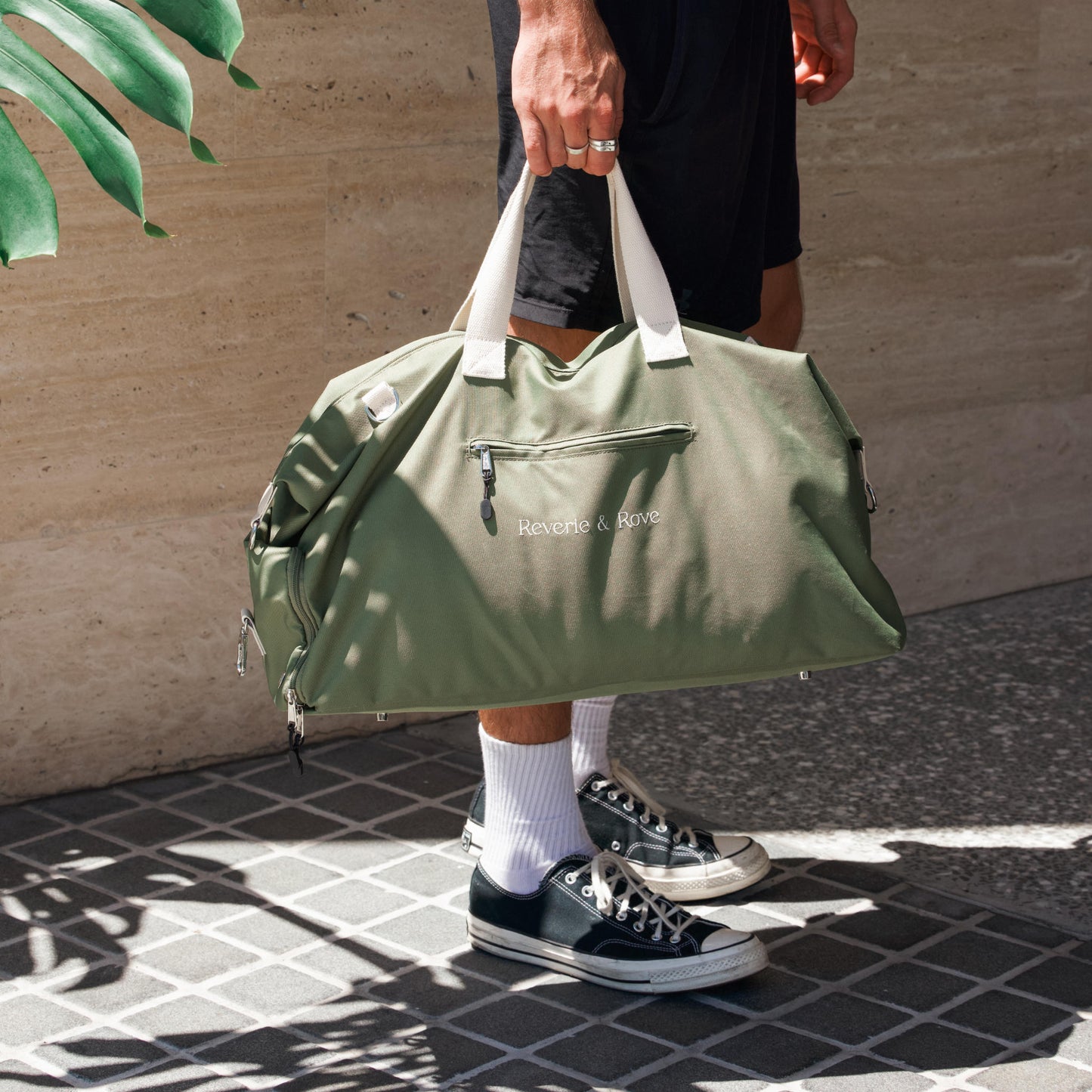 Green duffle bag lifestyle shot with male model